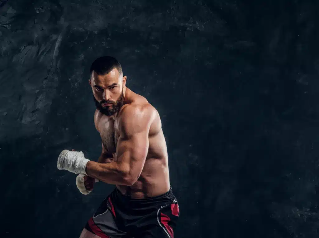 manly bearded man with beautiful muscular torso is posing photographer dark background